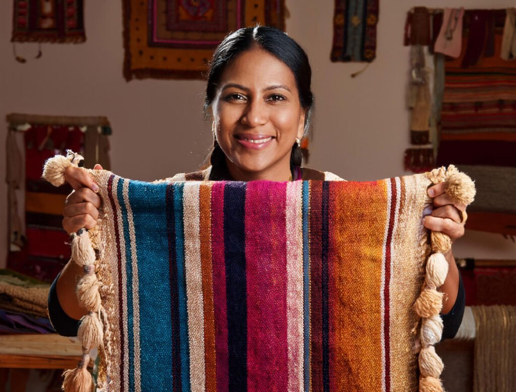 Artesanos mexicanos mostrando productos de lana terminados con orgullo.